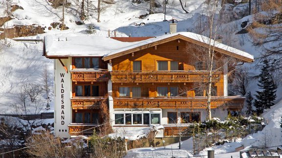 A cozy wooden house in the snow named "Waldesrand". Surrounded by snowy trees and a wintry landscape. - Appartements Waldesrand - Sölden