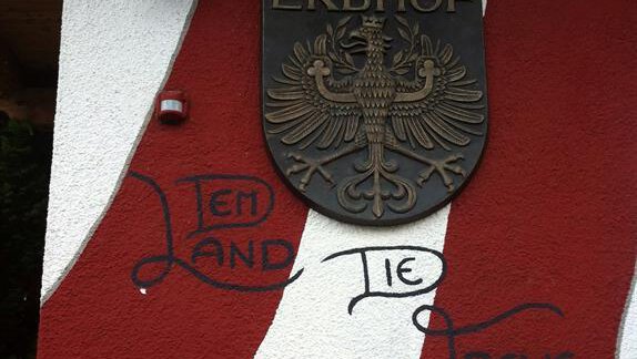 A coat of arms with an eagle on a wall in red and white. Below it, the inscription "Loyalty to the Country" stands. - Erbhof - Sölden