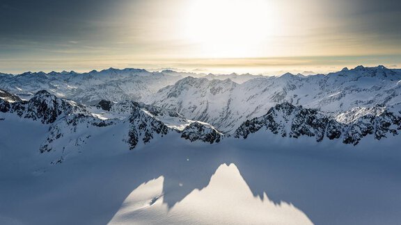 A breathtaking mountain landscape with snow-covered peaks under the radiant sun. The sky is clear and the landscape appears peaceful. - Ferienhaus Karlingerhof - Sölden