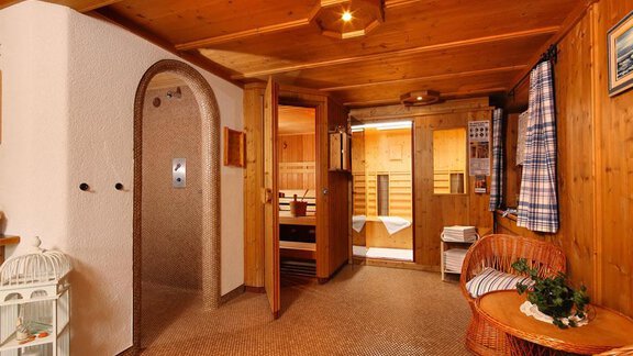 A cozy wellness oasis with wood paneling. The room features a sauna, a shower, and stylish furniture. - Haus Alpenstern - Sölden