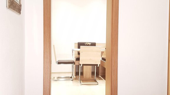 A bright room with an open door area. In the background, a table and chairs are visible. - Haus Christian - Sölden