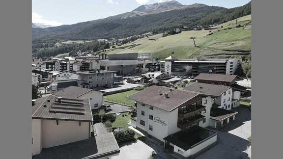 A tranquil mountain landscape with modern houses and surrounding meadows. In the background, the mountains are visible, completing the scene. - Haus Gabriela - Sölden