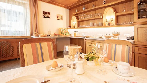 An invitingly set table in a cozy dining room. In the background, you can see a modern, well-equipped kitchenette. - Haus Montjola - Sölden