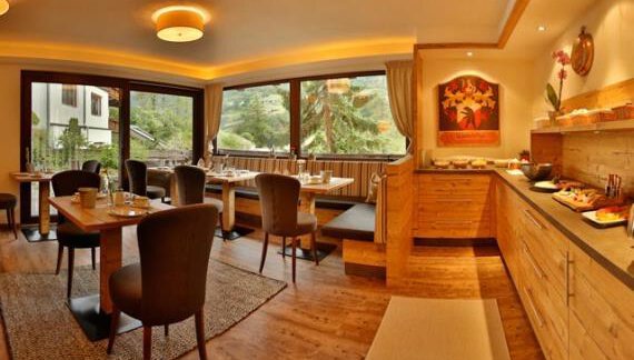 A cozy restaurant with wooden interior and large windows. The tables are set for guests, and the buffet is well prepared. - Haus Söldenblick - Sölden