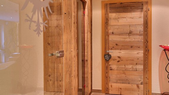 An inviting hallway with wooden doors and an elegant floor. The walls are designed to be bright and friendly. - Haus Söldenblick - Sölden