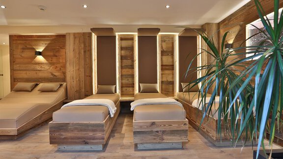 A modern wellness area with comfortable wooden loungers. The walls are clad with wooden panels, and a plant creates a relaxed atmosphere. - Haus Söldenblick - Sölden