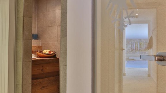 A modern hallway with a clear design. In the background, a wooden bench with fresh groceries can be seen. - Haus Söldenblick - Sölden