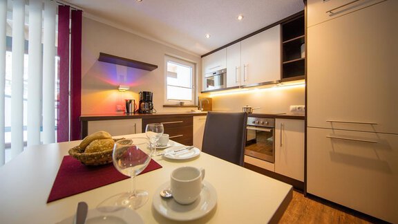 A modern kitchen with stylish furniture and good lighting. The table is set and invites you to a cozy meal. - Haus Stefanie - Sölden