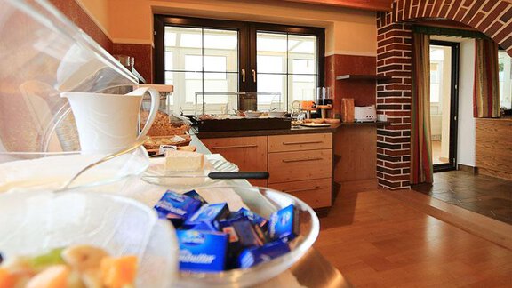 A cozy kitchen with a buffet full of fresh foods. The room has large windows and maintains an inviting atmosphere. - Haus Stefanie - Sölden