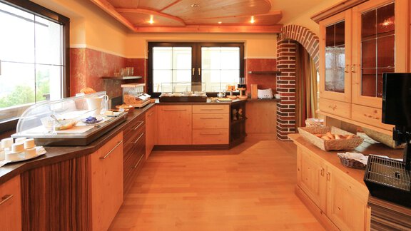 A modern kitchen with wooden cabinets and soft colors. It is well-lit and provides space for preparations. - Haus Stefanie - Sölden