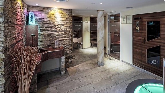 A stylish spa with soft lighting and modern facilities. The walls are adorned with stone, and there is a wellness area for relaxation. - Hotelappart Peter - Sölden