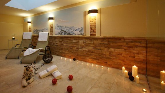 A luxurious spa with two relaxation loungers and soft lighting. Towels and decorative balls are on the floor to create a relaxing atmosphere. - Hotelappart Peter - Sölden | © Falkner Georg