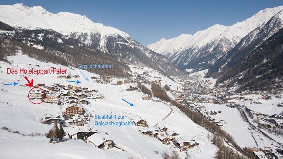 A snow-covered landscape with mountains and a small village. The signage indicates the Hotelappart Pater and the ski lift to Gaislachkogelbahn. - Hotelappart Peter - Sölden