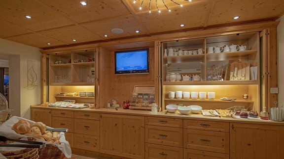 An inviting breakfast nook with wooden shelves and beautiful dishes. Fresh rolls and a selection of foods are laid out on the counter. - Hotelappart Peter - Sölden
