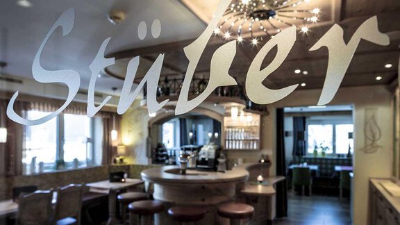 A cozy interior of a restaurant with a round counter area. Wooden elements are on the walls and a welcoming atmosphere. - Hotelappart Peter - Sölden