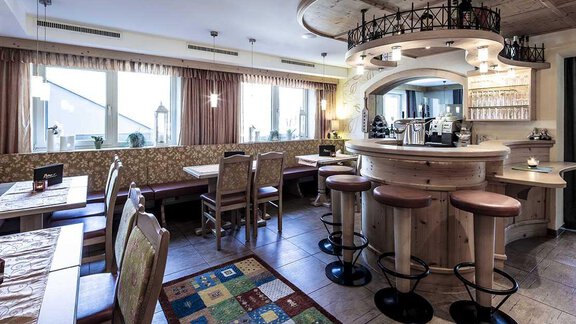 A cozy restaurant with wooden furniture and an inviting bar area. Large windows provide plenty of natural light. - Hotelappart Peter - Sölden