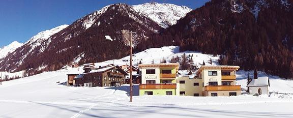A picturesque winter village with snow-covered hills and majestic mountains in the background. The modern buildings contrast with the untouched snow landscape. - Landhaus Fiegl Hubert - Sölden