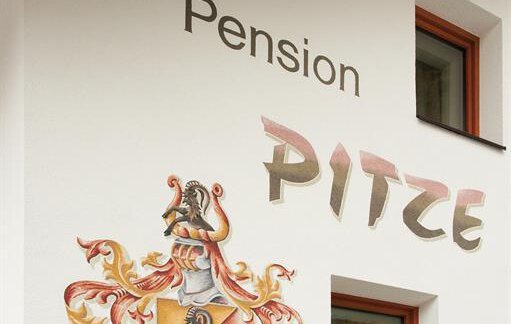 A guesthouse named "Pitze" is depicted on a wall. Below it is a coat of arms that has been in use since 1546. - Pension Pitze - Sölden