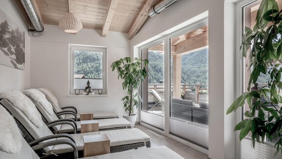 A cozy relaxation room with comfortable loungers and large windows. In the background, green plants and a beautiful view of nature can be seen. - Soelden Lounge - Sölden