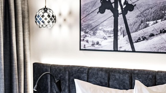 A modern bedroom with two beds and stylish lighting. A black-and-white picture of a mountain landscape hangs on the wall. - Sonnalp Residences - Sölden