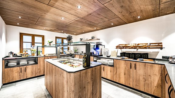 A modern kitchen with wooden cabinets and an elegant countertop. The room design is bright and welcoming. - Sonnalp Residences - Sölden
