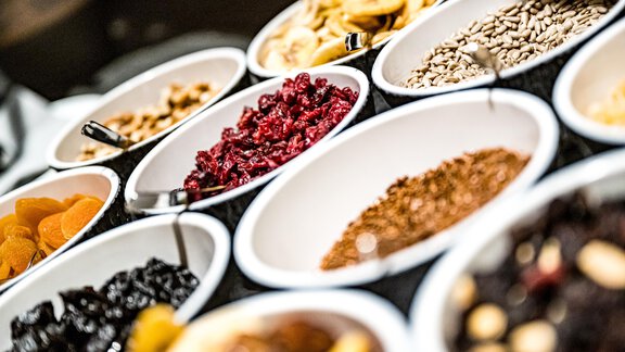 A selection of dried fruits and nuts in bowls. The colors and textures are diverse and inviting. - Sonnalp Residences - Sölden