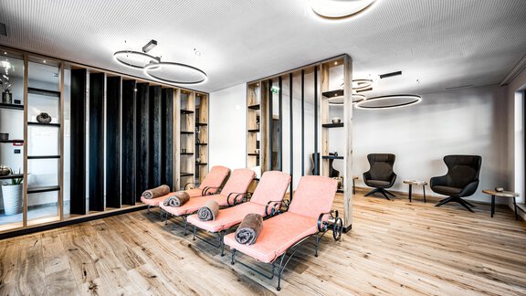 A modern spa with comfortable loungers and minimalist decor. The warm wood tones create a relaxing atmosphere. - Sonnalp Residences - Sölden