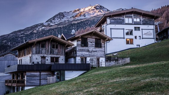 A picturesque mountain landscape with modern chalets. Snow-covered peaks can be seen in the background. - The Peak Sölden - Sölden