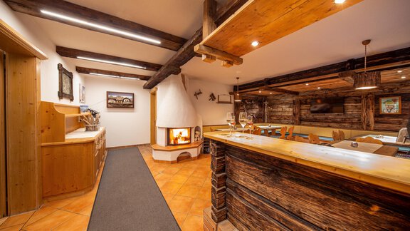 A cozy interior with a wooden bar and a fireplace. The room features rustic elements and warm lighting. - Toni's Ferienheim - Sölden