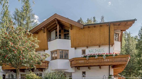 A modern, two-story building in Alpine style with wooden elements. Surrounded by trees and nature, it creates an inviting atmosphere. - Waldhäusl - Sölden