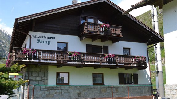 A charming wooden house with a balcony adorned with colorful flowers. The building bears the inscription "Appartement Auny". - Appt. Garni Anny - Vent