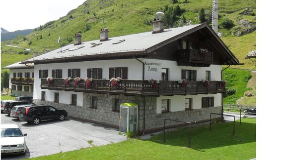 A typical mountain house with flower balconies, surrounded by green hills. Parking is available in front of the building. - Appt. Garni Anny - Vent
