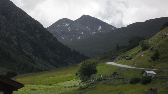 A picturesque mountain landscape with green meadows and high mountains in the background. The sky is cloudy, creating a tranquil atmosphere. - Appt. Garni Anny - Vent