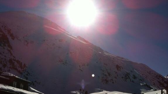 A sunny mountain landscape with snow and a clear blue sky. The sun shines brightly over the snow-covered hills. - Appt. Garni Anny - Vent