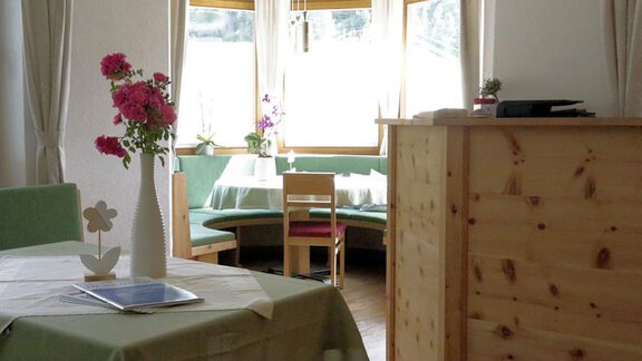 A cozy restaurant with wooden furniture and an inviting table. The large windows provide plenty of daylight and a pleasant atmosphere. - Gästehaus Soldanella - Vent
