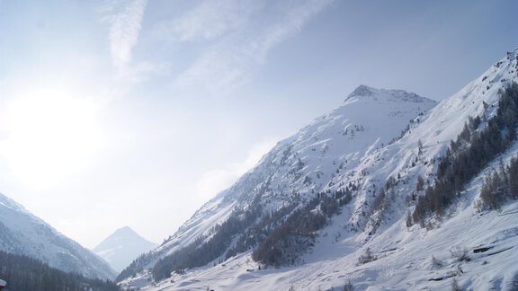 A picturesque mountain landscape with snow-covered peaks and clear sky. The deep valleys are covered in white snow. - Haus Weisskogelblick - Vent