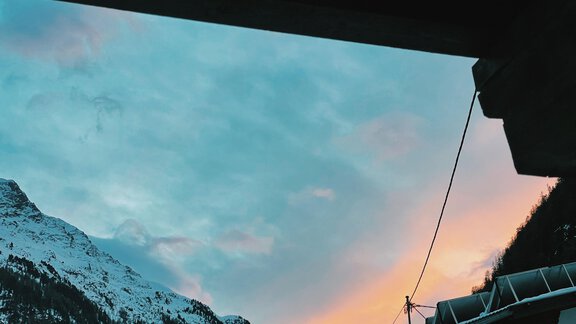A majestic mountain panorama with snow-capped peaks and a colorful sky at sunset. The clouds are tinted in soft shades of pink and blue. - Landhaus Rosenhof - Zwieselstein