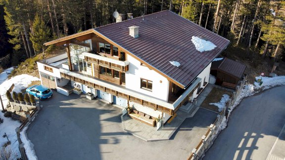Ein modernes Haus in den Bergen mit einem großen Parkplatz. Umgeben von Bäumen und Schnee. - Haus Falkner Karoline - Niederthai