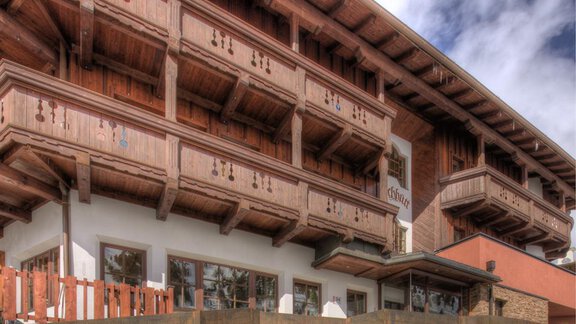 A cozy chalet with wooden balustrades and balconies. The sky is partly cloudy, creating an inviting atmosphere. - Hotel-Garni Pirchhütt - Obergurgl 