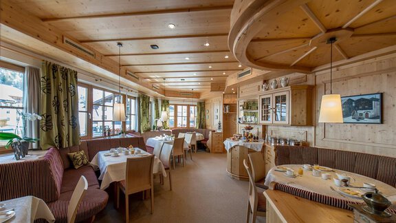 A cozy restaurant with wood paneling and elegant tables. The atmosphere is bright and inviting, ideal for a meal with friends or family. - Hotel-Garni Pirchhütt - Obergurgl 