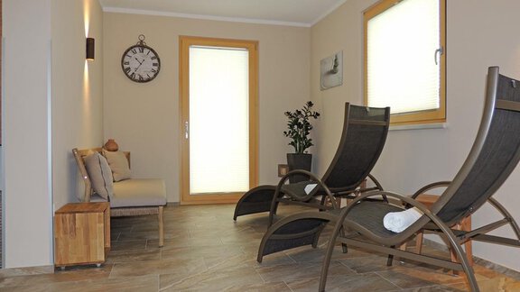 A quiet room with two loungers and a window. The walls are light, and there is a plant as well as a clock on the wall. - Haus Christophorus - Obergurgl 