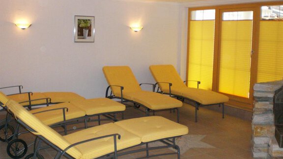 A relaxing room with yellow loungers and large windows. Soft lighting creates a calm atmosphere. - Pension Angern - Obergurgl 