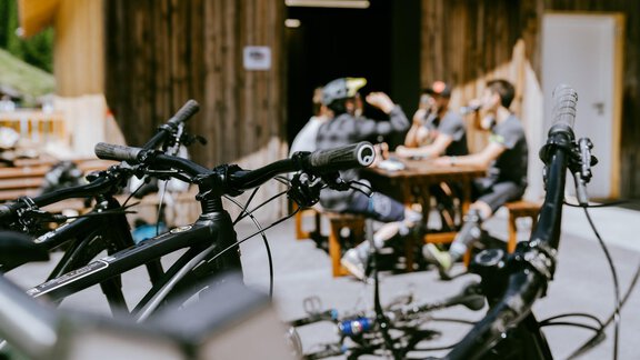 A group of cyclists is sitting at a table in a cabin. In the foreground, bicycles can be seen. - Anraitl Appartements Sölden - Sölden
