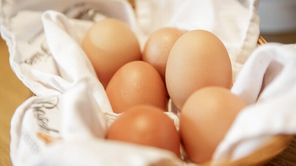 A bowl with seven eggs resting on a white cloth. The eggs are in different sizes and shades. - Apart Garni Enzian - Sölden | © RudiWyhlidal