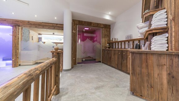 A modern wellness area with wooden shelves and a reception desk. The room is bright and inviting, with fresh towels and a relaxing atmosphere. - Apart Hotel Garni Alt Kaisers - Sölden