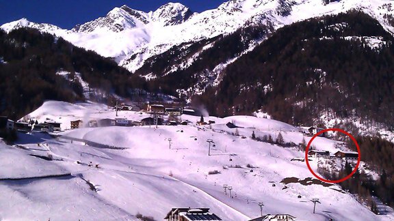 A snowy mountain landscape with snow-covered slopes and high mountains in the background. In the foreground, buildings and ski lifts can be seen. - Brandlehof - Sölden