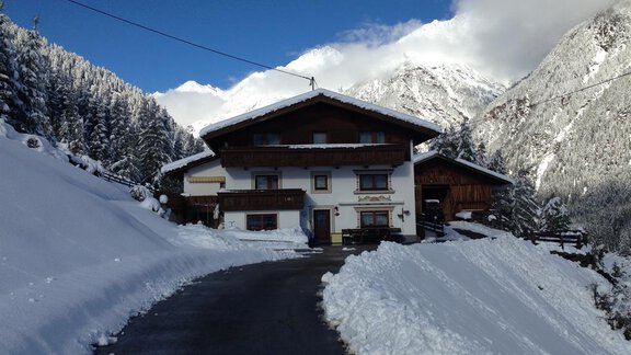 A cozy house in the mountains, surrounded by snowy landscapes. The sky is clear with some clouds. - Brandlehof - Sölden