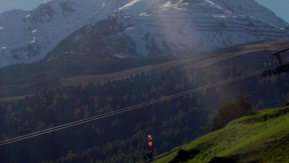 A picturesque mountain landscape with snow-capped peaks and lush, green grass. The clear, sunny atmosphere gives the scenery a peaceful mood. - Brandlehof - Sölden