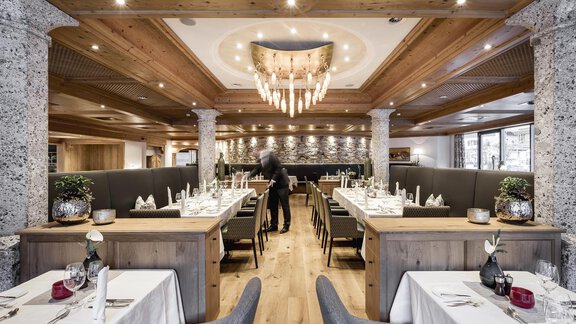 Ein elegantes Restaurant mit Holzdekor und modernen Möbeln. Die Tische sind festlich gedeckt und die Beleuchtung sorgt für eine gemütliche Atmosphäre. - Das Central - Alpine . Luxury . Life - Sölden | © Rudi Wyhlidal