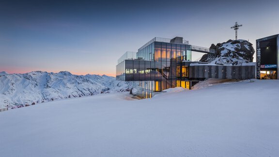 A modern building on snow-covered terrain with the impressive mountain landscape in the background. The sky is clear and radiates a peaceful evening atmosphere. - Haus Gabriela - Sölden
